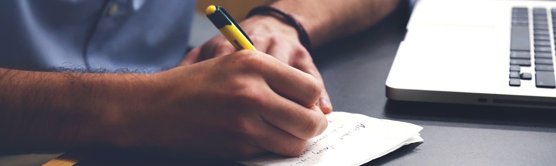 Prise de notes à côté d'un ordinateur portable